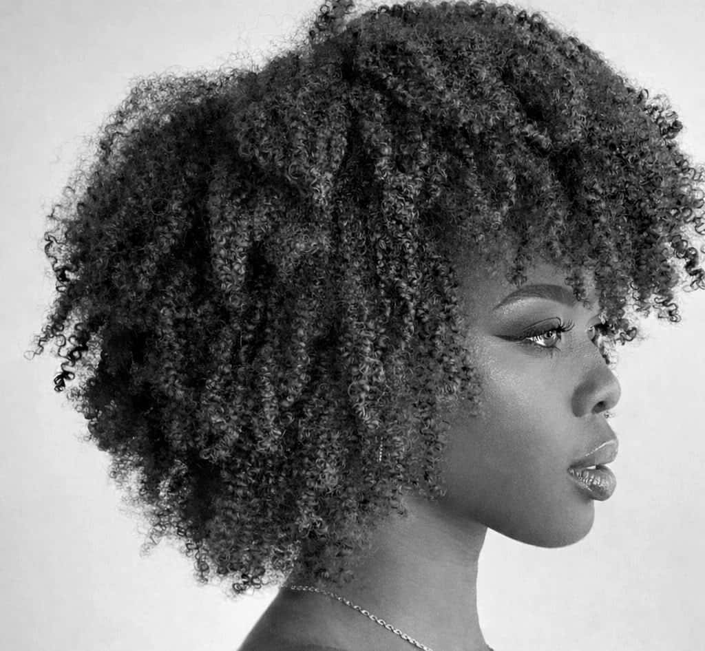 Femme de profil avec des cheveux naturels bouclés et volumineux